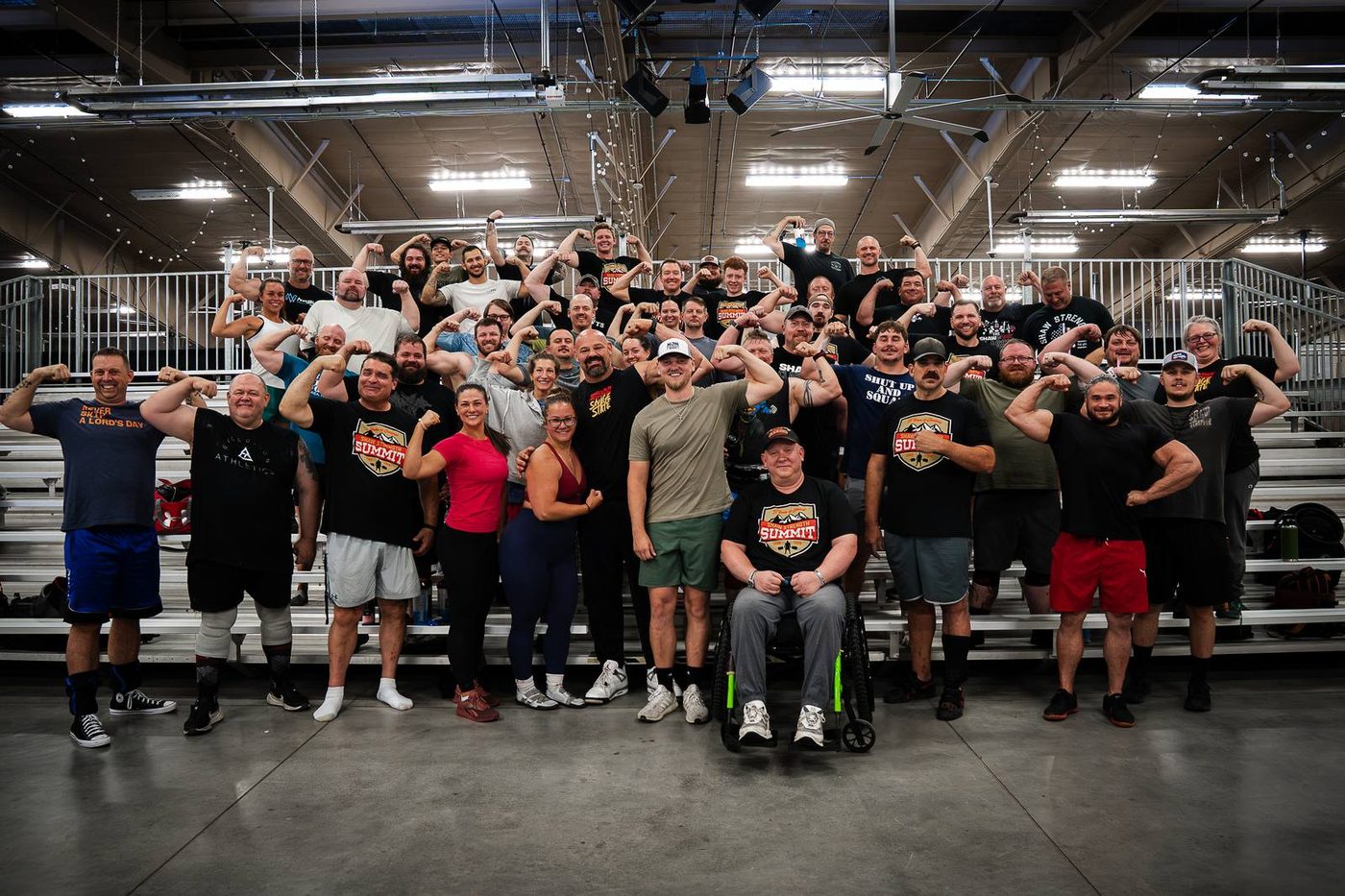 Group photo of attendees flexing at the Shaw Strength Summit in Estes Park, Colorado